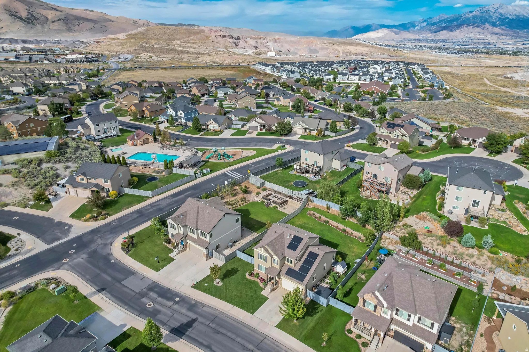 Residential neighborhood with varied architectural styles, green spaces, and a community pool