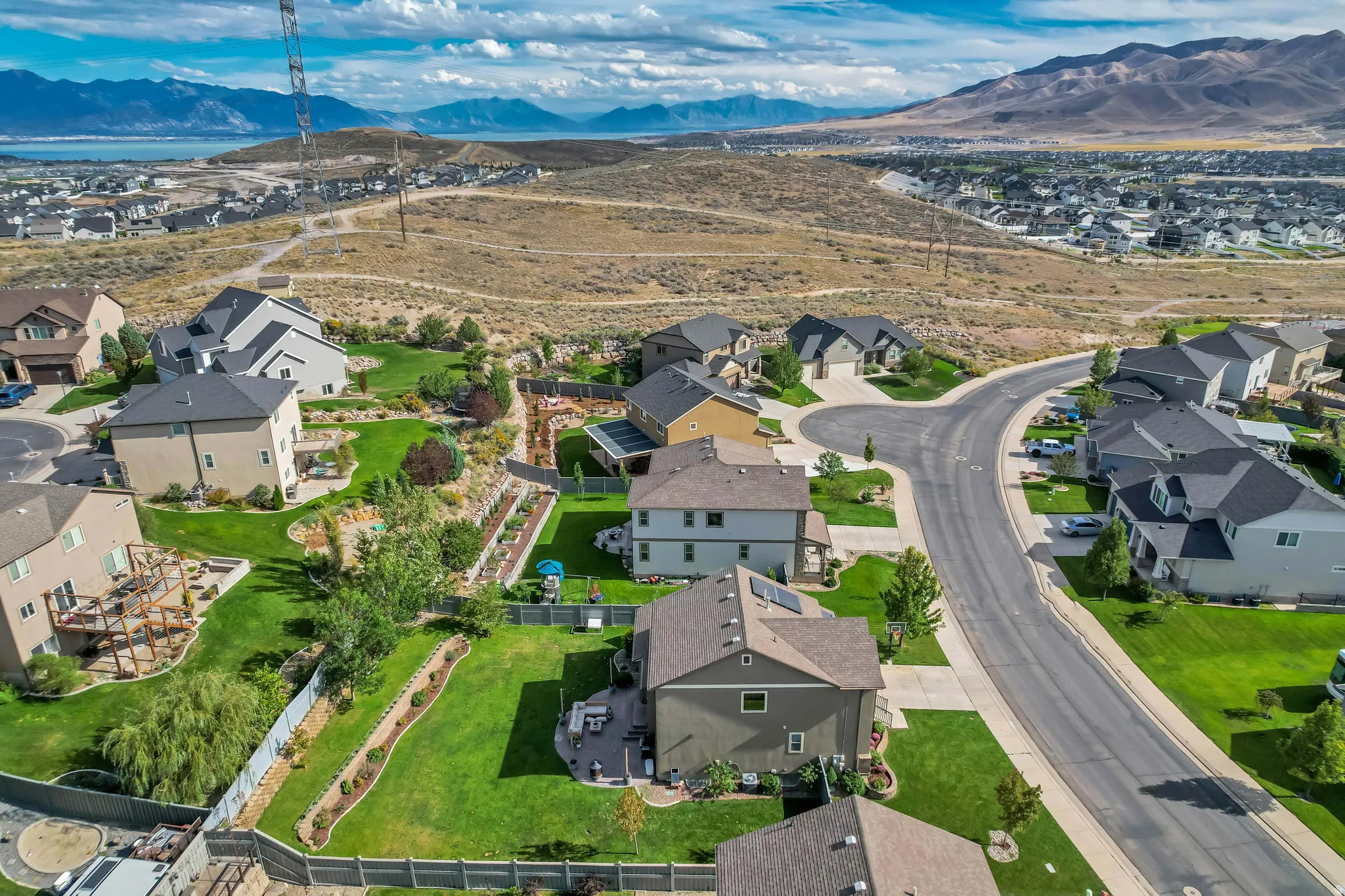 Residential neighborhood featuring a cul-de-sac, multiple homes with landscaped yards, and mountain scenery