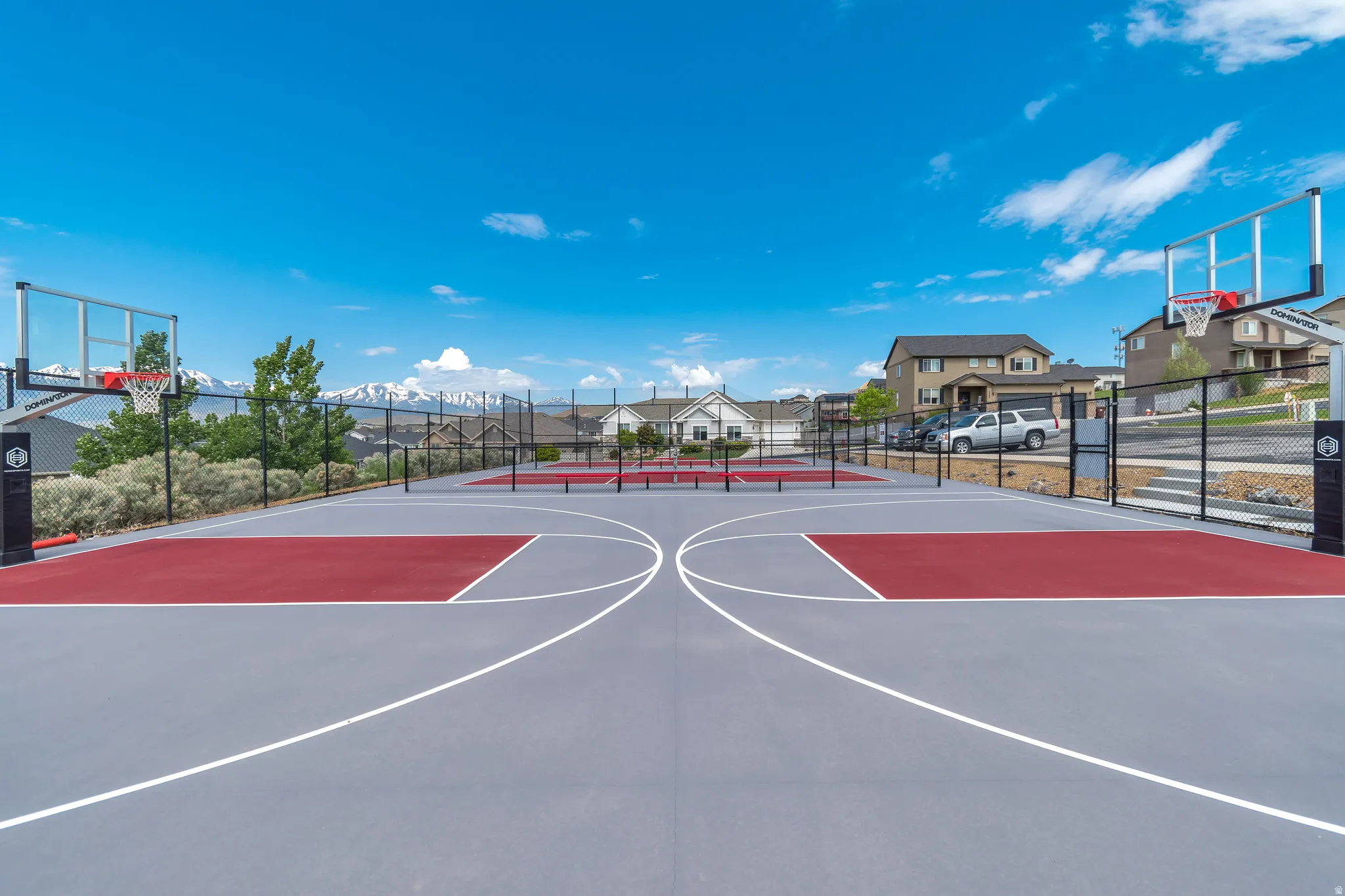 Two full-size basketball courts featuring gray and red playing surfaces