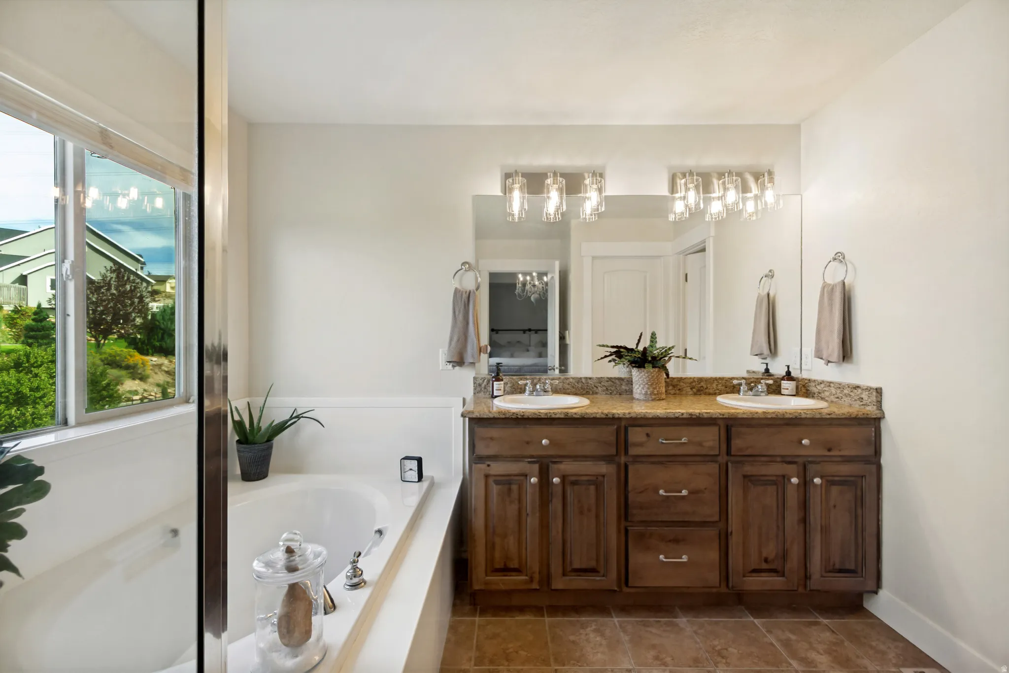 Dual vanity with wood cabinetry and stone-finish countertop