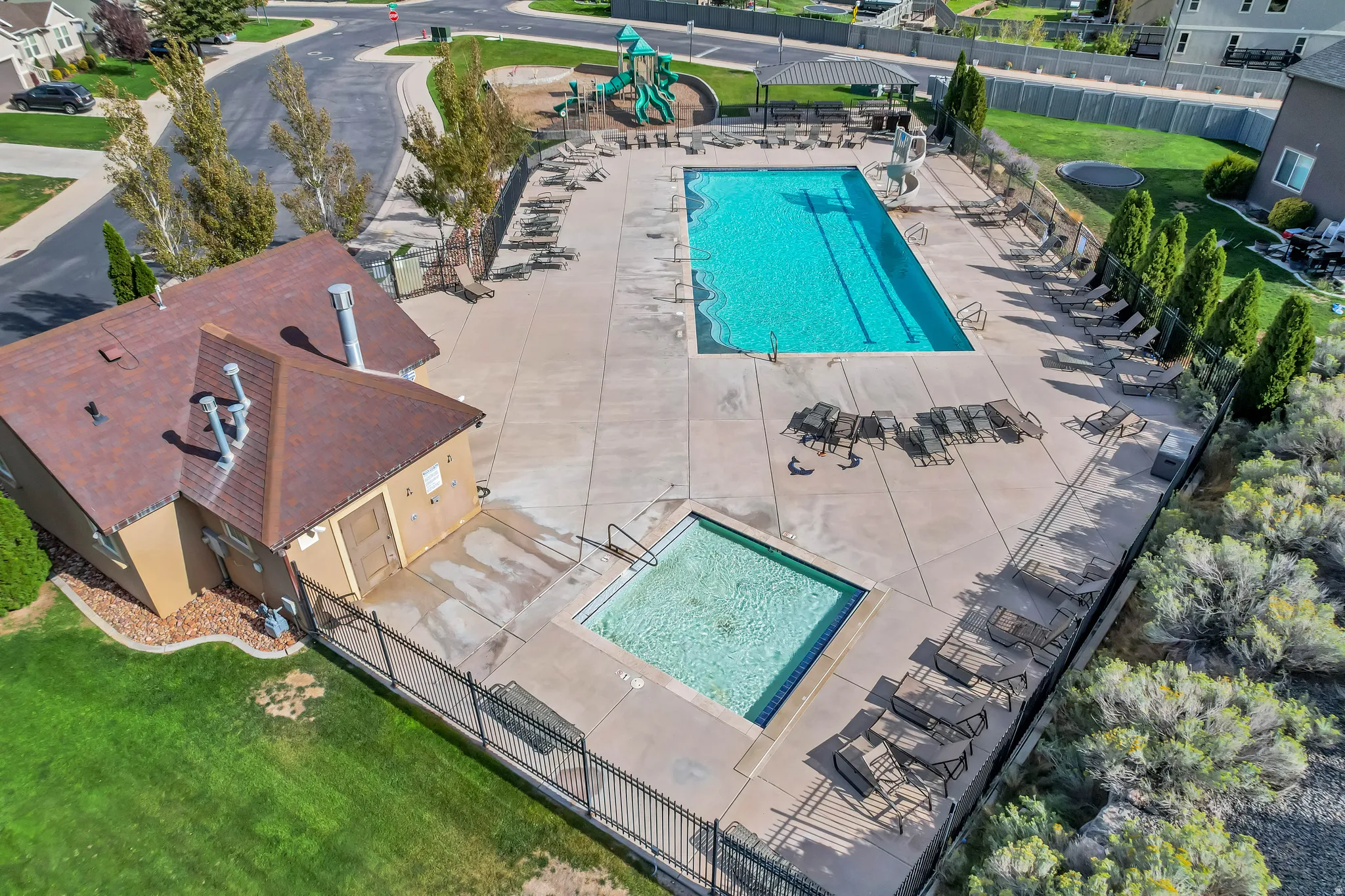 Outdoor swimming pool with integrated spa and surrounding concrete deck