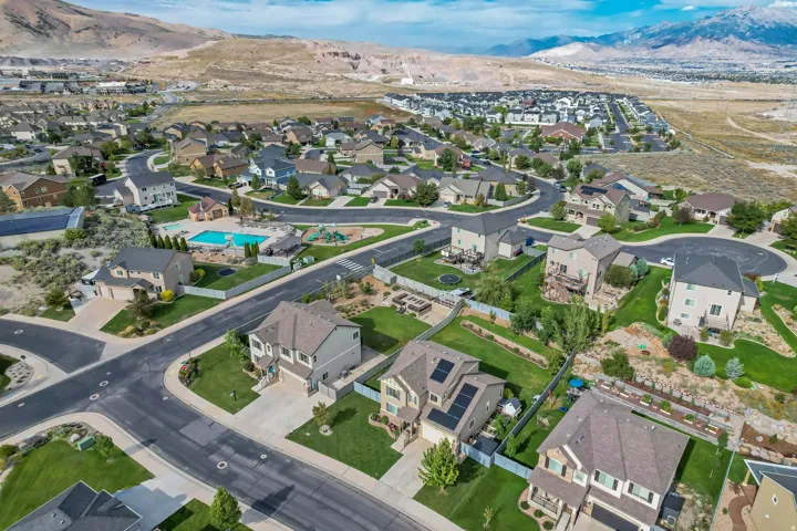 Residential community featuring single-family homes, paved roads, and a community pool area with a playground