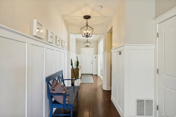 Hardwood flooring, wainscoting, recessed wall lighting, paneled doors, and ceiling-mounted light fixtures