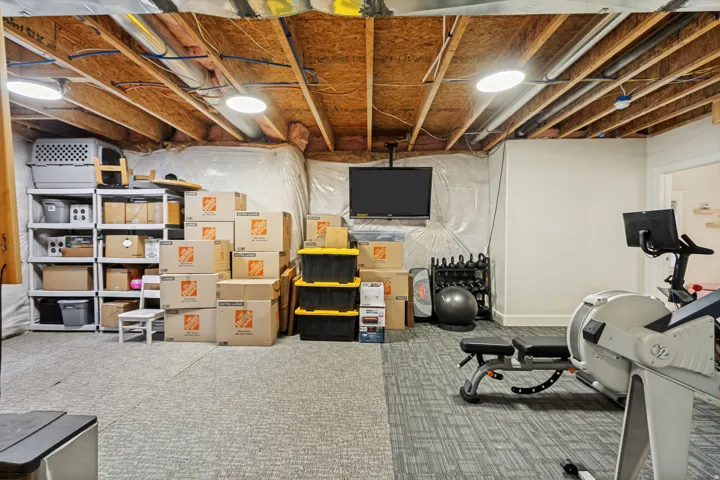 Exposed wood beam ceiling, recessed lighting, and carpeted flooring