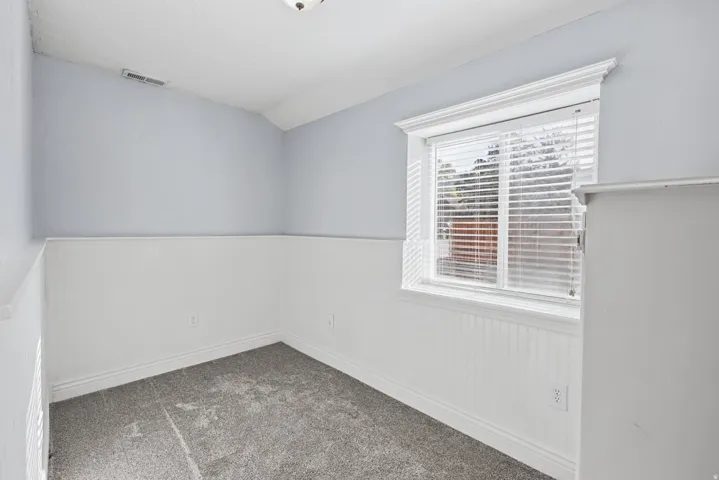 Bedroom featuring wainscoting, a window with blinds, and carpeting