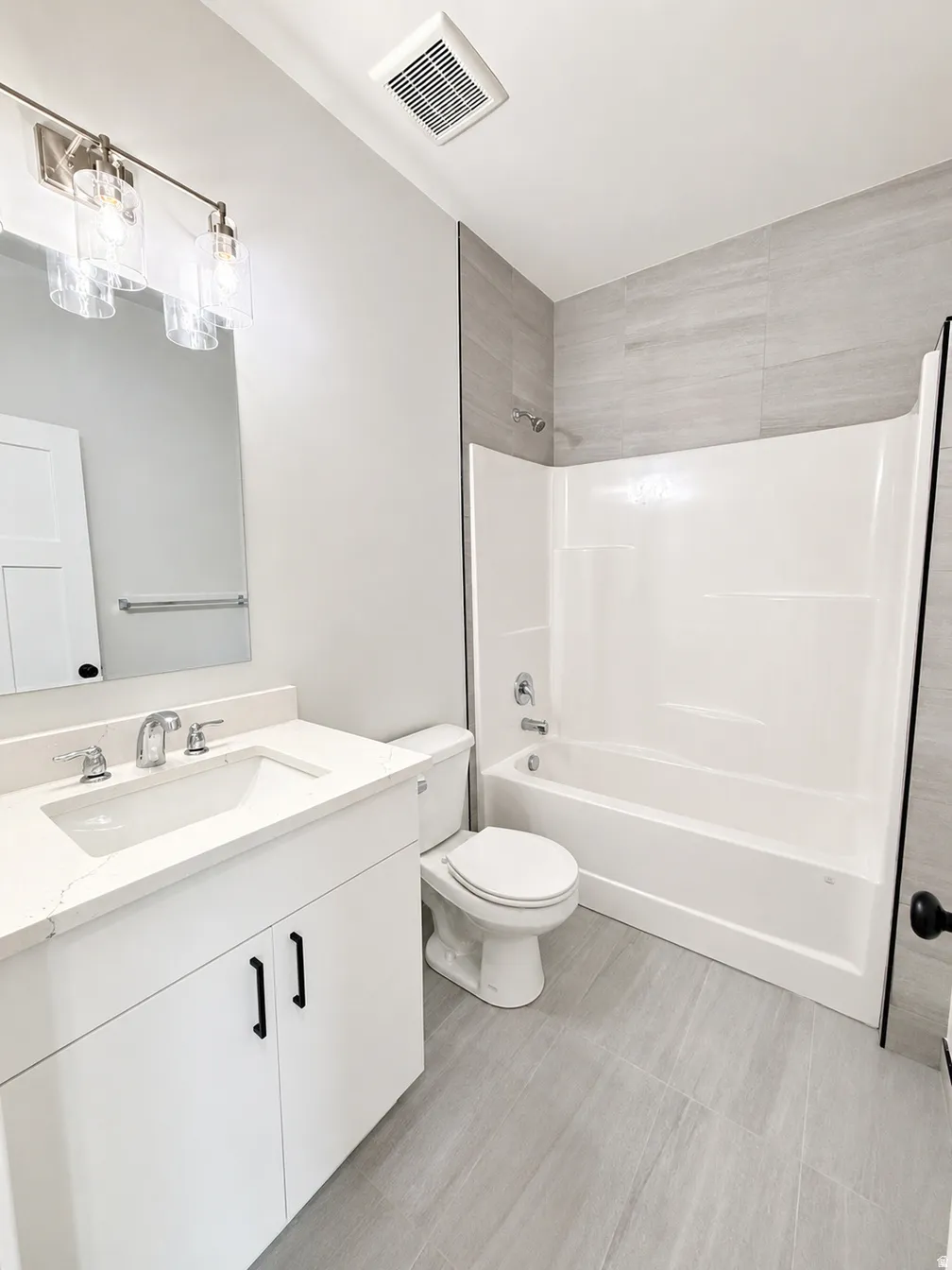 White vanity with a single basin sink and stone countertop