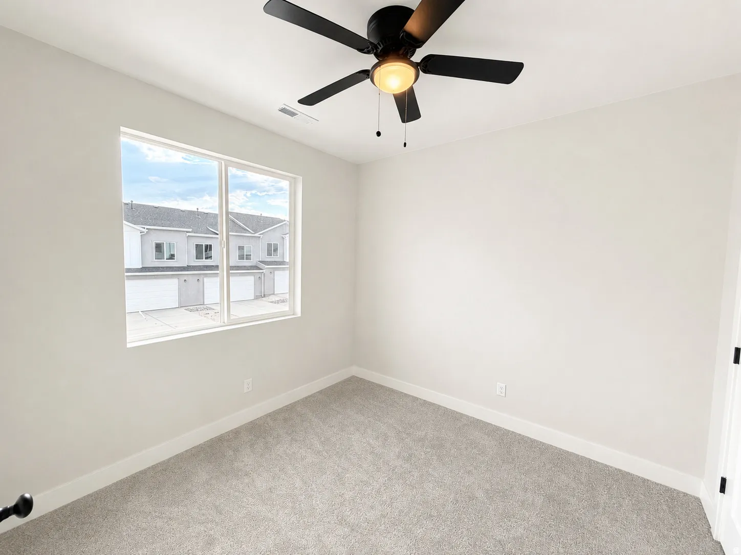 Neutral tone wall paint, light-toned carpet flooring, white trim, recessed lighting, and a modern ceiling fan