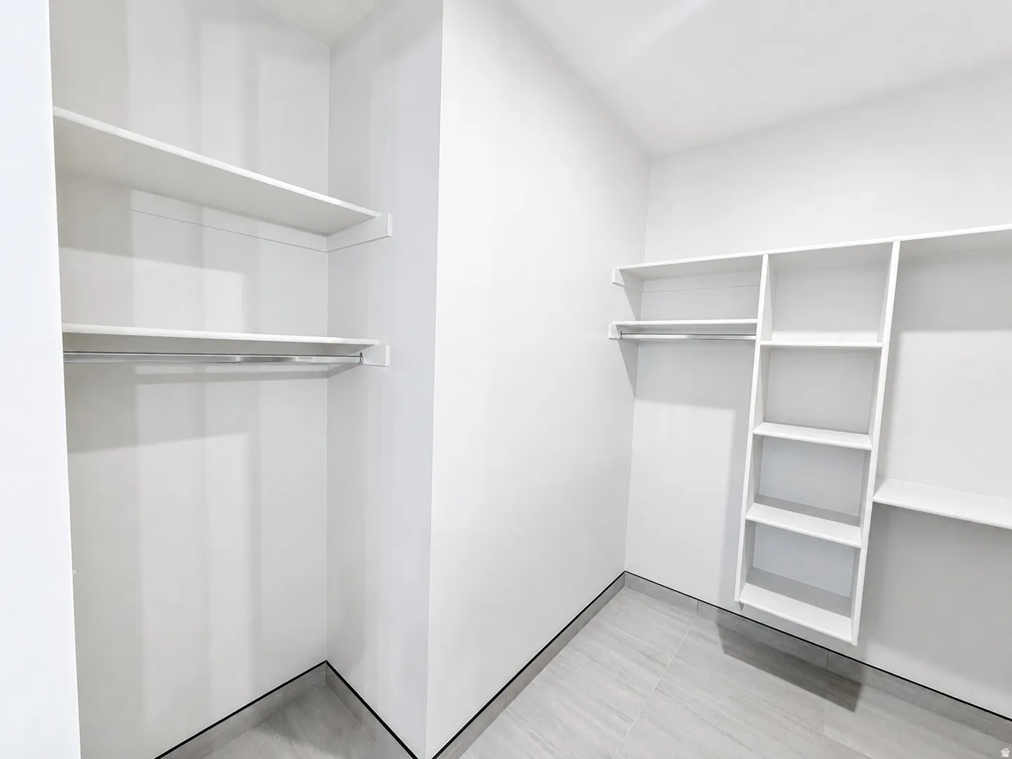 Built-in shelving, hanging rods, and tile flooring