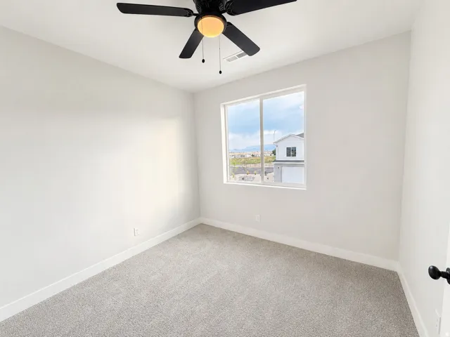 Neutral wall finishes complement the gray carpet and white trim