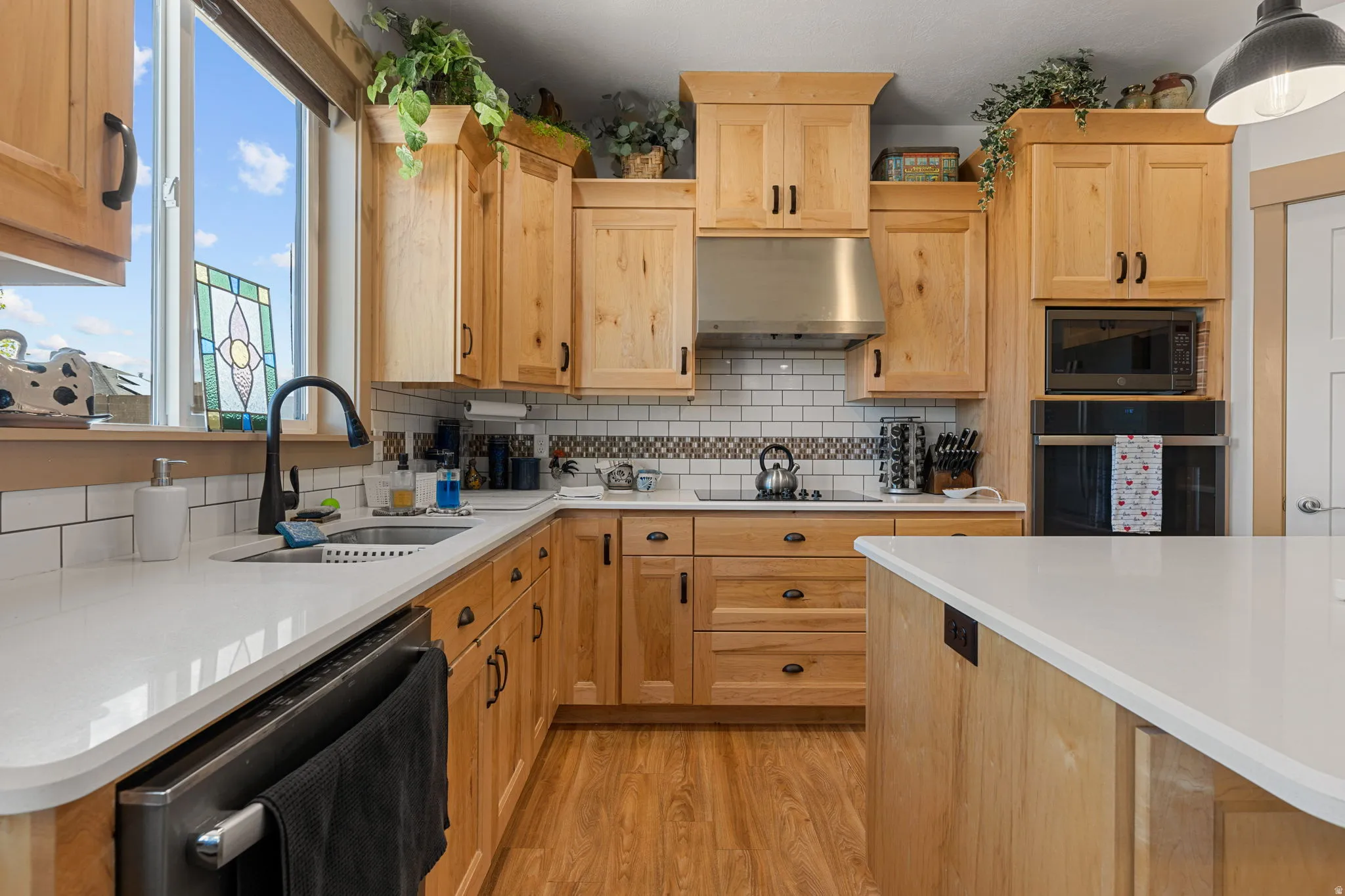 Wood-finish cabinetry paired with white countertops and a subway tile backsplash