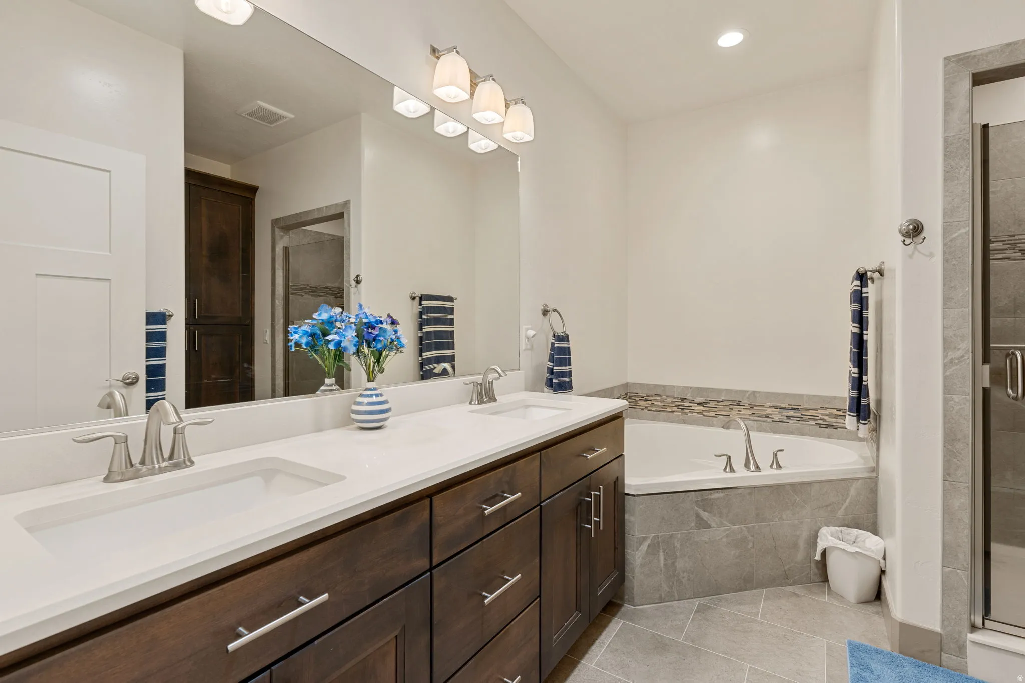 Dual vanity with white countertops, dark wood cabinetry, and brushed nickel fixtures