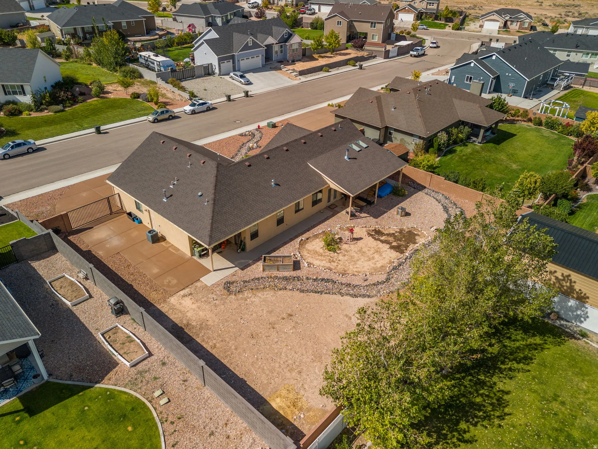 Expansive backyard featuring a covered patio, xeriscaping, and a privacy fence