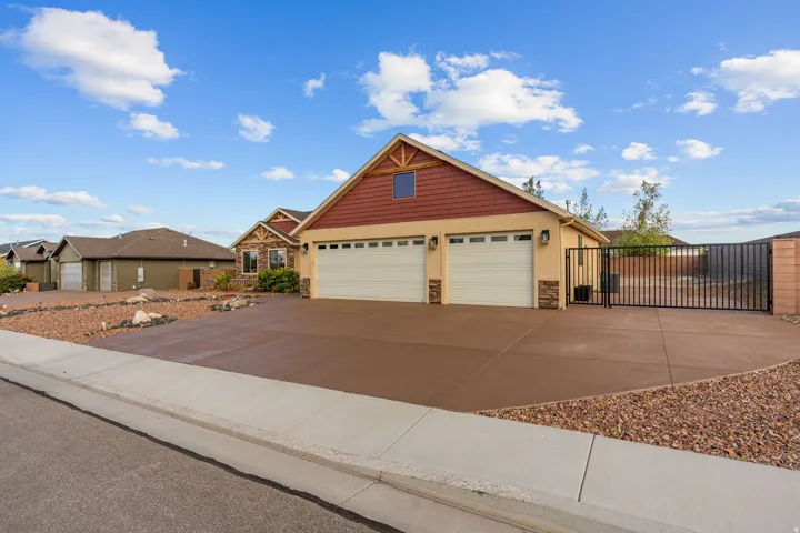 Property exterior featuring an attached two-car garage, stucco finish, wood-look siding, and a decorative stone facade
