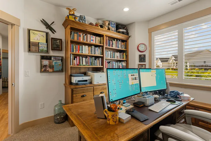 Built-in wood shelving, wood-finish flooring, recessed lighting, and window shutters