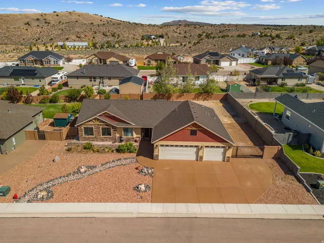 Single-story residence featuring a two-car garage, stone and shingle exterior accents, and a front yard with decorative rock landscaping
