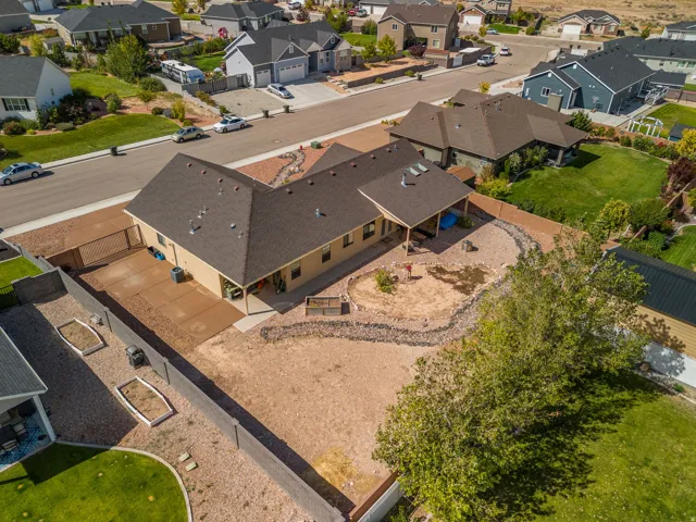 Expansive backyard featuring a covered patio, xeriscaping, and a privacy fence