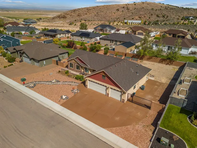Two-car garage with concrete driveway, red siding, and brown roof shingles