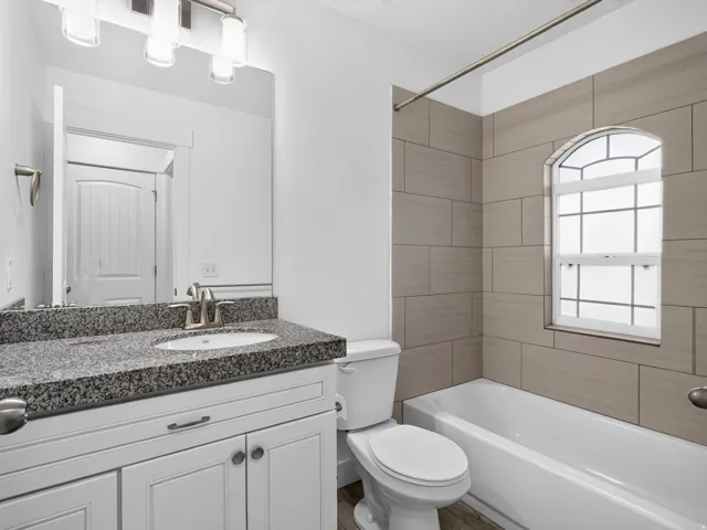 Bathroom featuring a white vanity with a dark speckled countertop, undermount sink, and brushed nickel fixtures