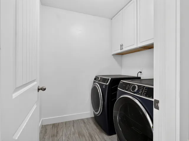 Upper cabinetry with silver hardware, and wood-finish flooring