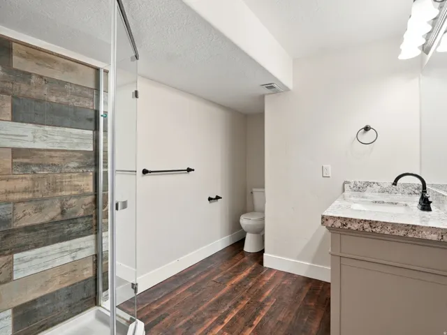 Glass-enclosed shower with wood-finish wall tile