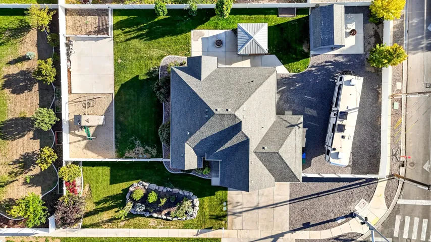 Expansive property featuring a multi-gabled roofline, a large paved driveway, a manicured lawn area, and a dedicated gravel area