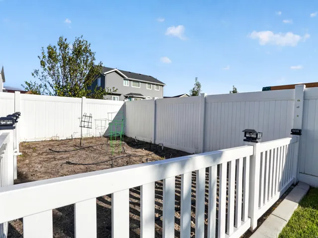 Enclosed yard space with white privacy fencing and a white railing