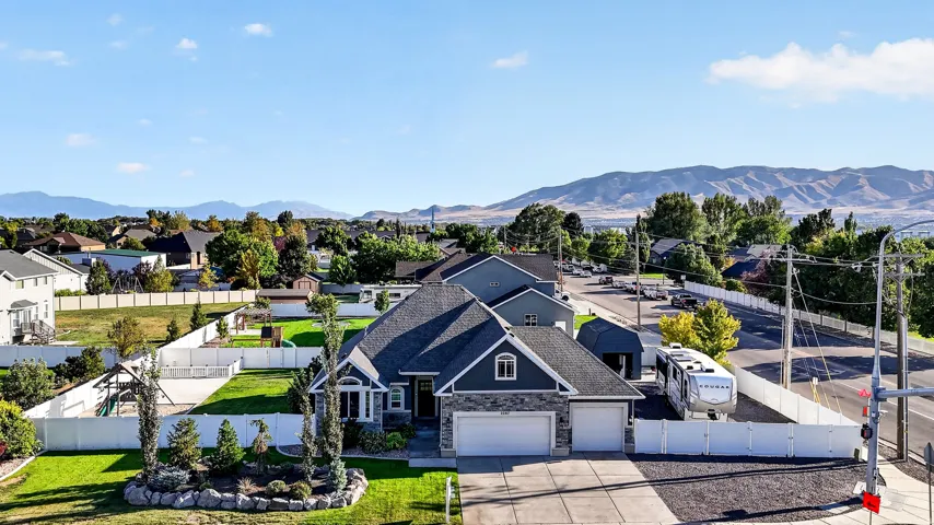 Two-car garage, manicured front lawn, and paved driveway