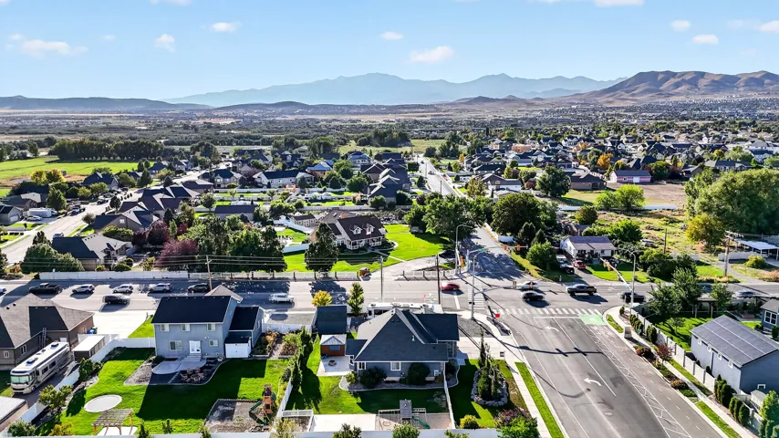 Residential neighborhood setting with clear mountain backdrop, mature trees, and paved roads