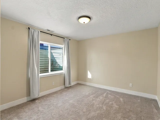 Recessed window with white trim, tan wall paint, and light-colored carpeting