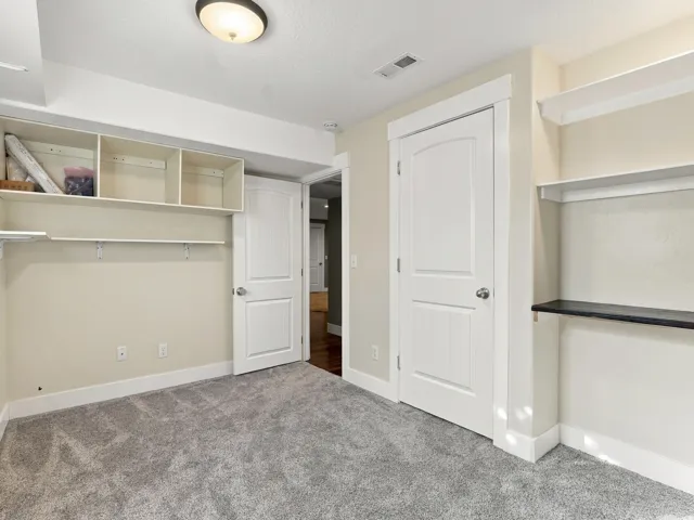 Gray carpeting, light-toned walls, and white trim