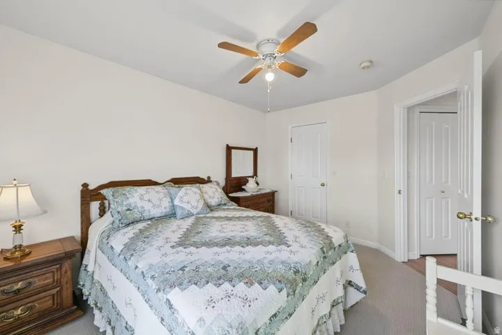 Neutral wall color, ceiling fan with light fixture, carpeted flooring, and white paneled doors