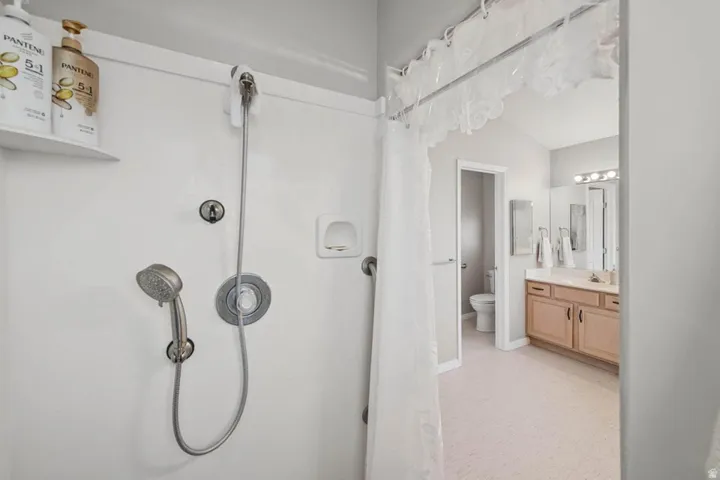 Shower with a handheld spray fixture and built-in shelving