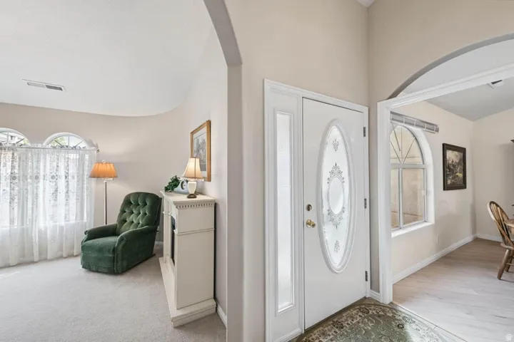 Entryway featuring a white door with an oval-shaped glass insert and a sidelight