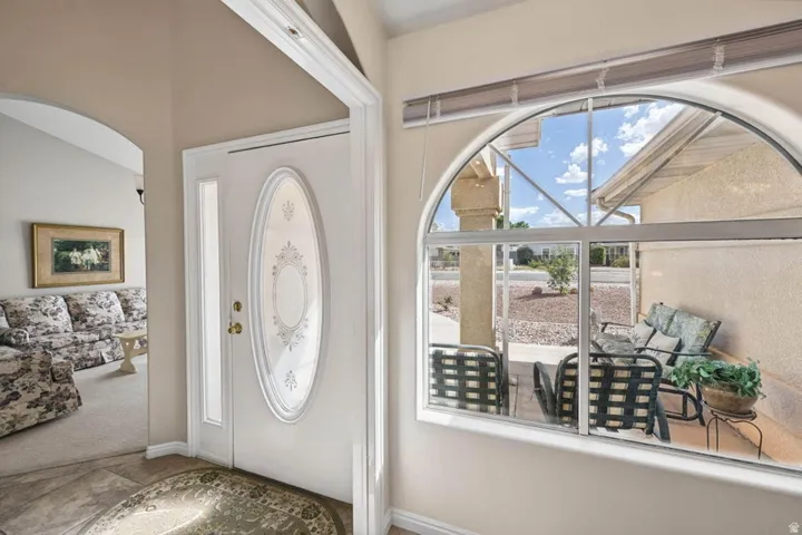 Arched window featuring a segmented design, white frame, and a partial outdoor patio