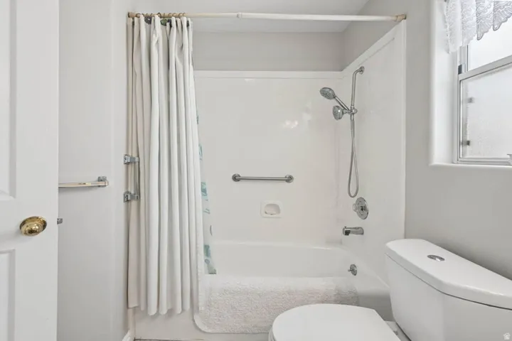 Tub and shower combination with chrome fixtures and grab bars