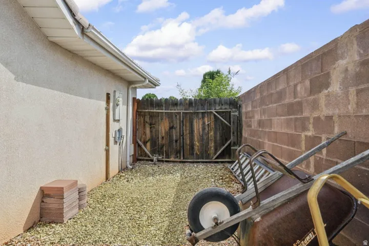 Gravel ground cover, stucco exterior, privacy fencing, block wall, and rain gutter system