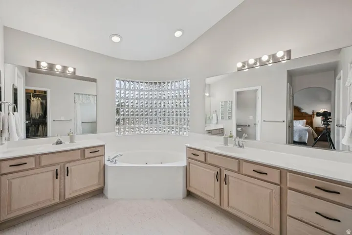 Dual vanity with neutral cabinetry, white countertops, and integrated sinks