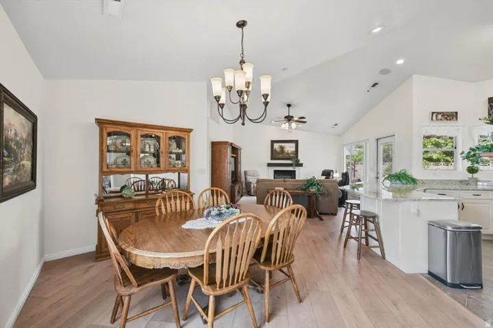 Open-concept living space with wood-finish flooring, vaulted ceilings, and a built-in fireplace