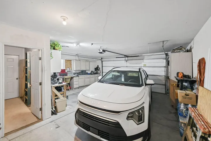 Attached two-car garage with white paneled garage doors