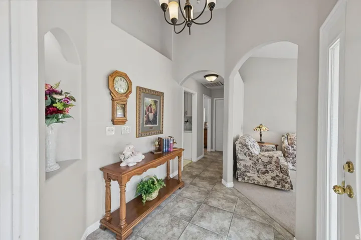 Arched doorways, tile flooring, interior lighting fixtures, and a wall niche
