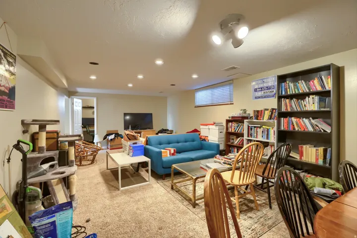 Recessed lighting, track lighting, and a window with blinds provide illumination
