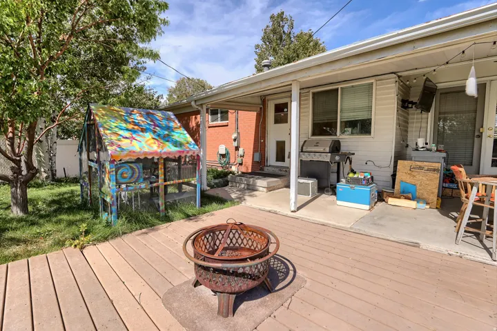 Expansive backyard featuring a composite deck, covered patio, and a dedicated fire pit area