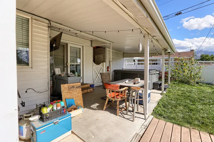 Covered patio area with concrete flooring, supported by structural posts