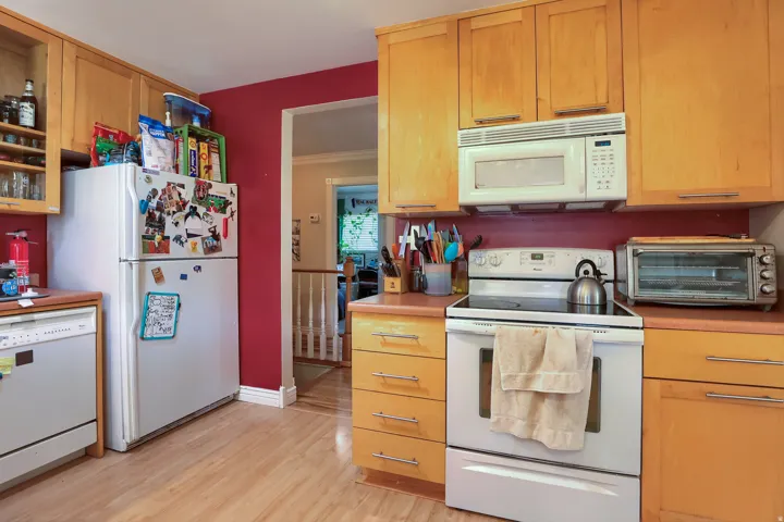 Kitchen featuring wood-finish cabinetry, solid surface countertops, a built-in microwave, and wood-finish flooring