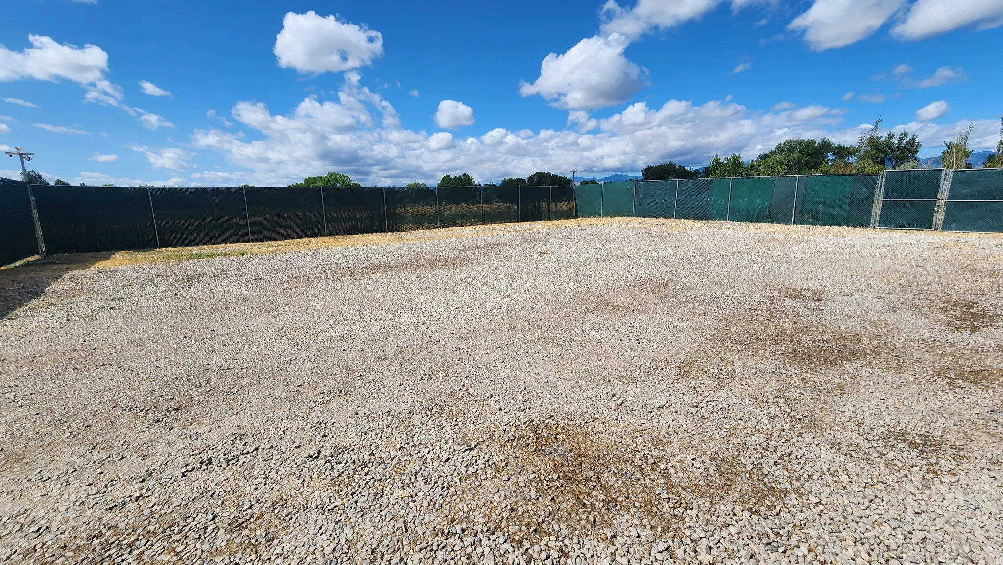 Gravel surface lot with perimeter fencing