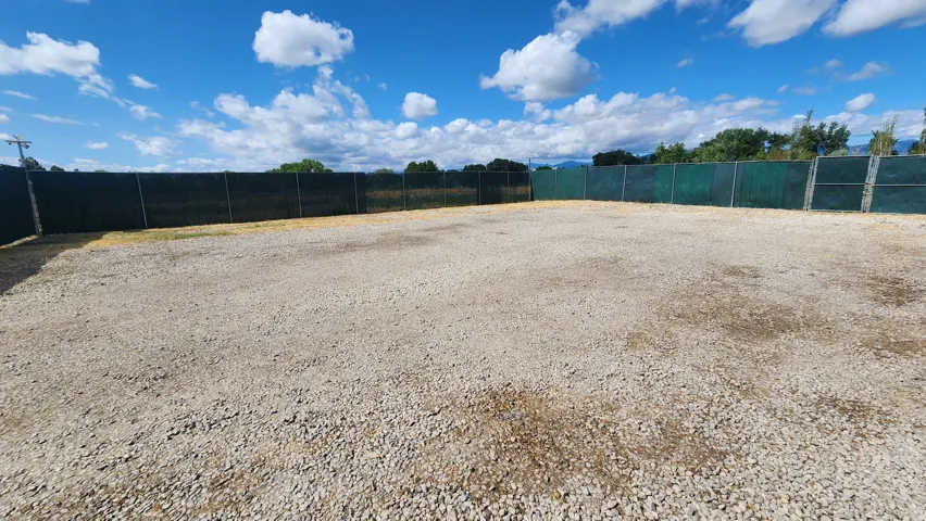 Gravel surface lot with perimeter fencing