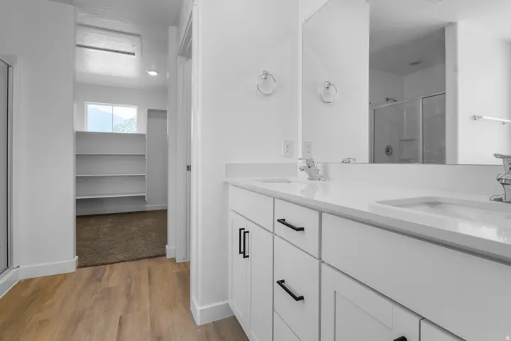 Dual vanity with integrated sinks, white countertops, and black cabinet hardware