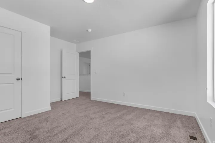 Plush carpet flooring, white painted walls, recessed ceiling lighting, and crisp white trim