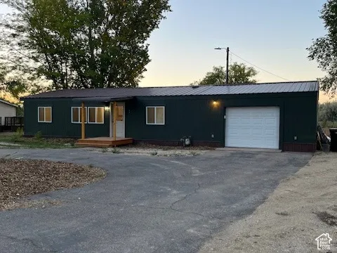 Dark green exterior siding with a metal roof and a white garage door