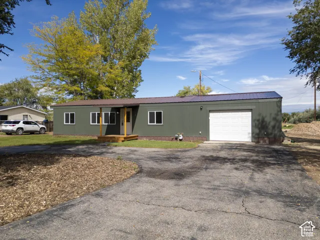 Single-story residence featuring a carport, a two-car garage, and a covered porch entry